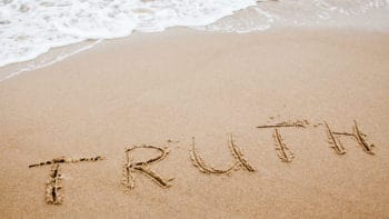 Word truth written on the sand